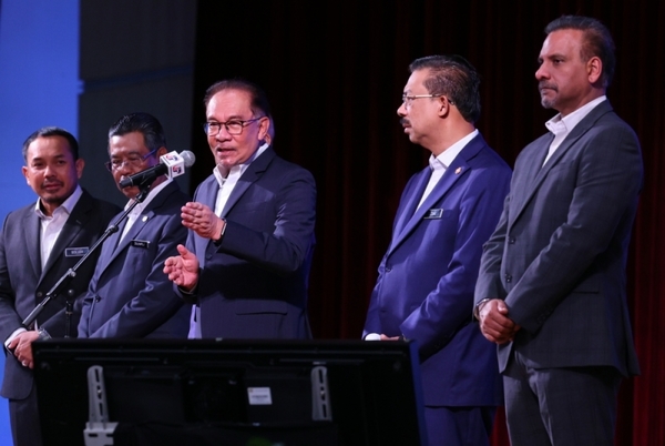 Anwar (centre) speaks during a meeting with staff of the Prime Minister's Department.