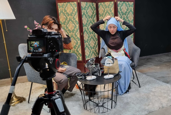 Dina (right) demonstrates how she styles her hijab to portray Ganyu from 'Genshin Impact'.