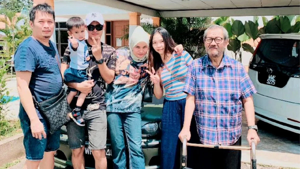 Salinah's biological father (first person from the right), Salinah (middle), and her adoptive father (last person on the right).