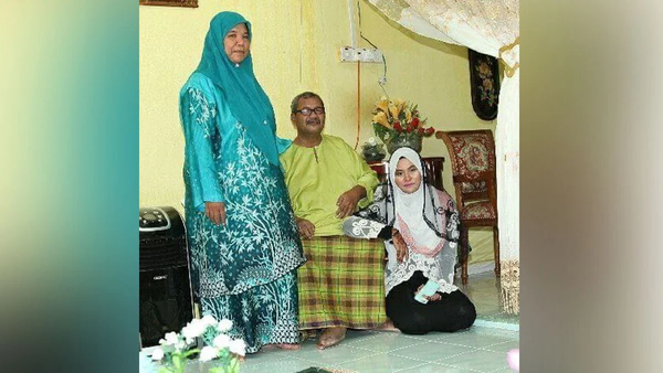 Salinah (far right) with her adoptive father and mother.