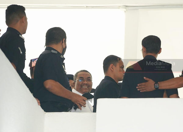 Sanusi (middle) appearing at the Selayang Session Court today, 18 July.