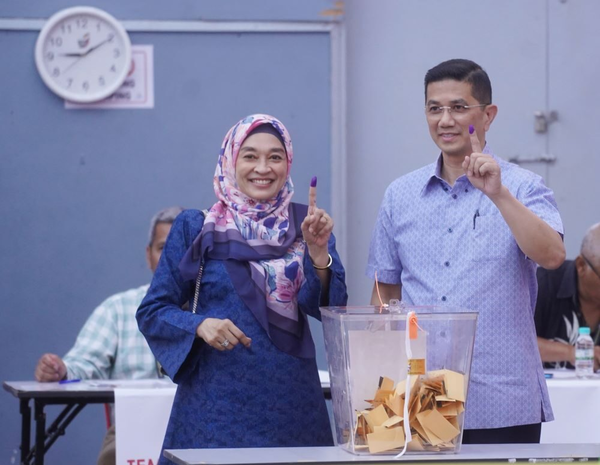 Azmin Ali with his wife, Datin Seri Shamsidar Taharin, at the SK Klang Gate polling station today, 12 August.