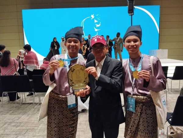 Wan Amzar Izzuddin (kiri) dan Abdul Muizz (kanan) bergambar kenangan selepas menerima medal dan trofi kemenangan.