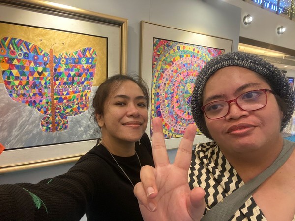 Armani Shahrin (left), with her sister Izzati, posing in front of Izzati's artworks.