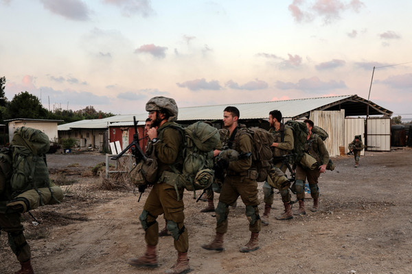 Israeli soldiers gather following a mass infiltration by Hamas gunmen from the Gaza Strip, in Kibbutz Beeri in southern Israel on 11 October.