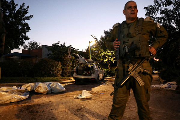 An Israeli military officer stands in front of dead bodies as they lay on the ground following a mass infiltration by Hamas gunmen from the Gaza Strip, in Kibbutz Beeri in southern Israel on 11 October.