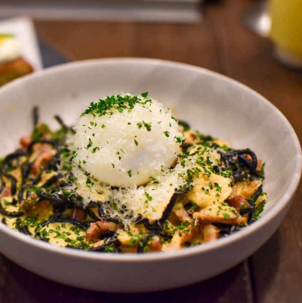 Squid Ink Tagliolini Carbonara with Smoked Bacon on Soft Boiled Egg.