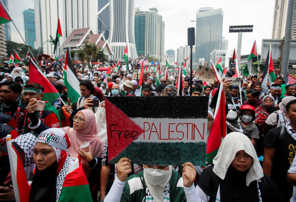 A protester holds a placard painted with the Palestinian flag and written with the slogan 'Free PALESTIN' during a protest outside the US embassy in support of Palestinians in Gaza at Kuala Lumpur on 28 October 28