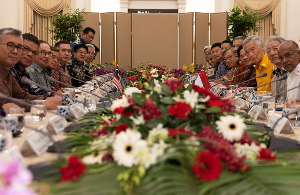 Anwar (3-L) and his Singapore counterpart Lee Hsien Loong (3-R) pose for a photo with other delegates during a delegation meeting at the Presidential Palace in Singapore, on 30 October.