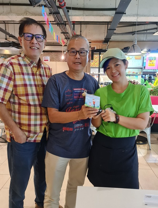 A DIB staff giving out a Father's Day gift to a customer.