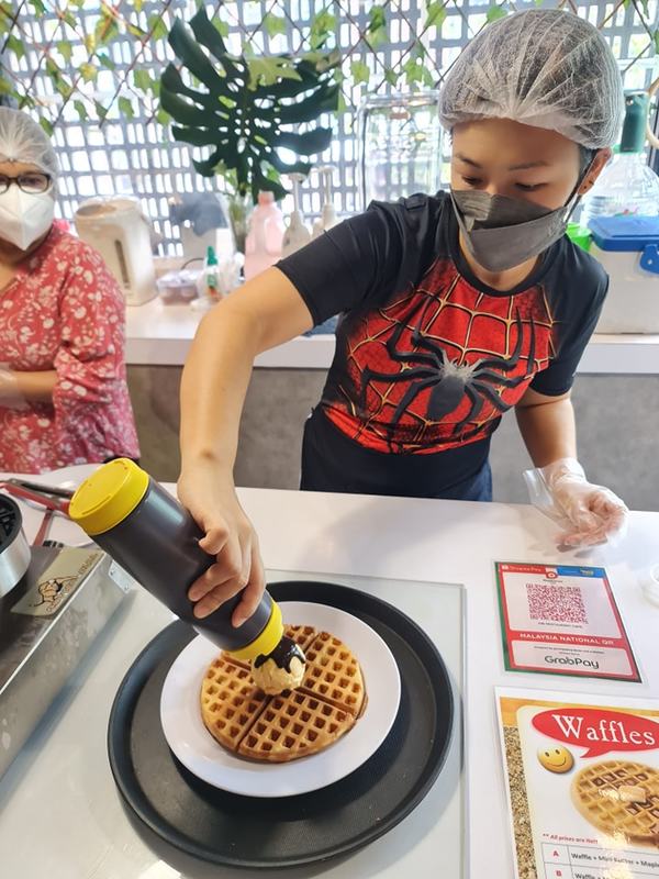 A DIB staff preparing waffles.