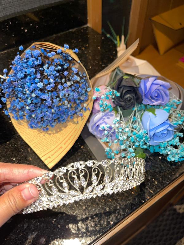 Behind-the-scenes photo of her preparing the flower crown in her hotel bedroom.