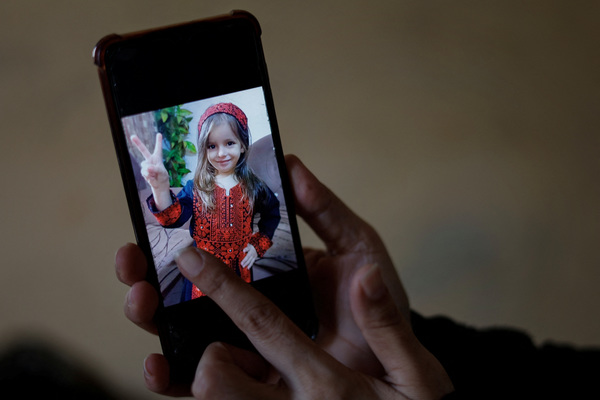 Inas Abu Maamar displays Saly's picture on a mobile phone, in Khan Younis in the southern Gaza Strip, on 26 October.