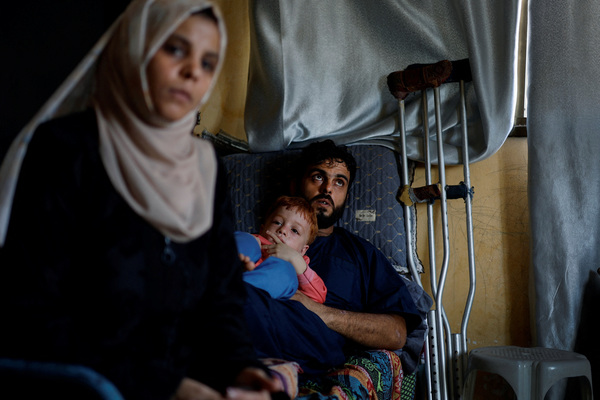 Inas Abu Maamar sits next to her brother Ramez, the father of Saly, as her nephew Ahmed, four, looks on, in Khan Younis in the southern Gaza Strip, on 26 October.