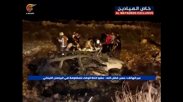 Footage from Al-Mayadeen TV shows emergency teams working next to a burnt vehicle at the scene where Hezbollah says an Israeli strike killed three children, in southern Lebanon, 5 November