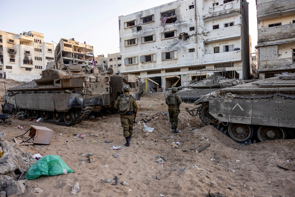 Israeli soldiers walk through rubble, amid the ongoing ground invasion against Palestinian Islamist group Hamas in the northern Gaza Strip, 8 November 2023.