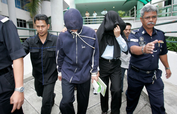 Policemen Azilah Hadri (second from the left) and Sirul Azhar Umar (second from the right) arrived at the courthouse in Shah Alam outside Kuala Lumpur on 15 January 2009.