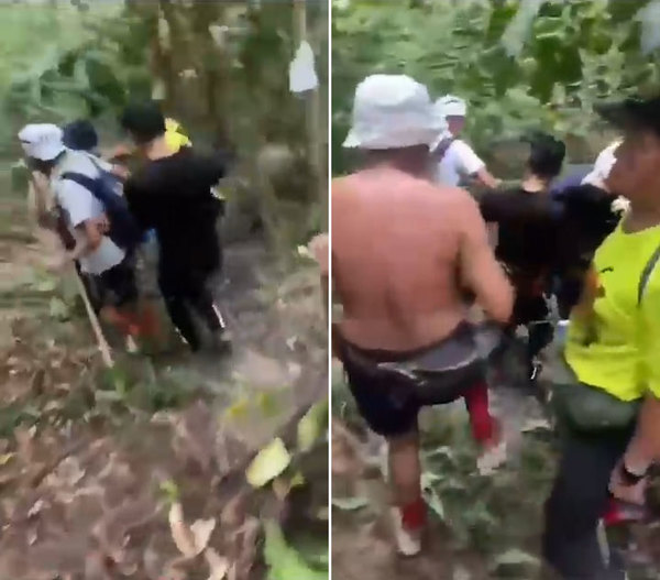 A group of passers-by carrying the victim out of the hiking trail.