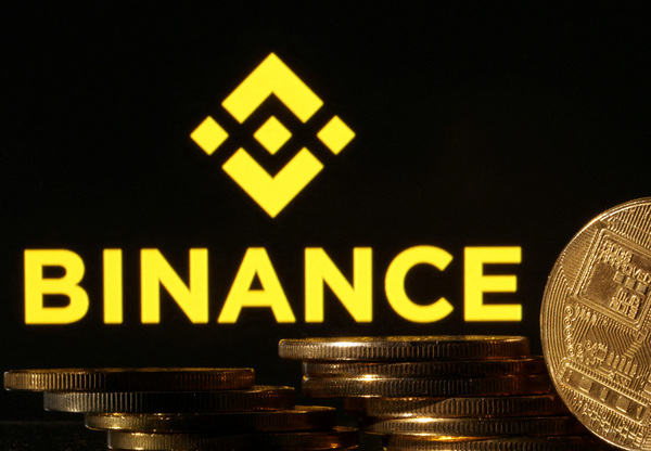 Representations of cryptocurrencies are seen in front of the Binance logo in this illustration.