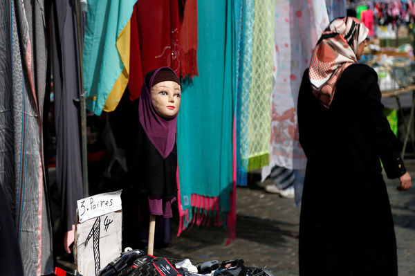 File photo of a woman walking past a mannequin wearing a hijab at a market in the Brussels district of Molenbeek, Belgium.