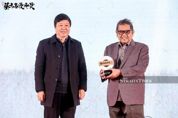 Datuk Lat (right) receiving the award at the 3rd Cai Zhizhong Comic Prize award ceremony held in Guangzhou, China, last Friday.