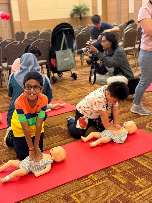 Children from the SunMed Kid's Club learn how to perform CPR.