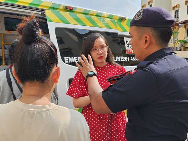 Ng is seen speaking with the police outside the laundromat in USJ 8.