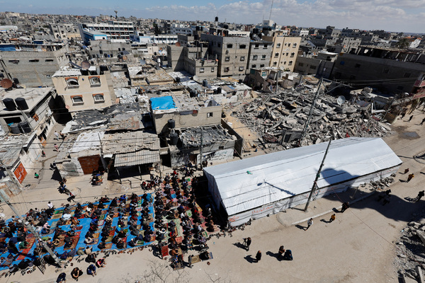 Palestinians perform first Friday prayers during Ramadan near the ruins of the destroyed Al-Farooq Mosque on 15 March.