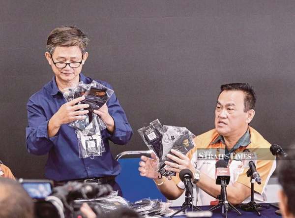 Xin Jian Chang Sdn Bhd owner Soh Chin Huat (left) and KK Super Mart and Superstore Sdn Bhd founder Datuk Seri Dr KK Chai displaying some of the socks.