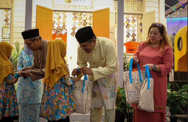 From left to right: Khairul Azizi Ismail, Chief Executive Officer of Boustead Properties Berhad, Jazmi Kamarudin, Chief Operations Officer of Boustead Properties Berhad, and Elaine Liew, Centre Manager of the Curve, presenting Raya packets and gift bags with essential Raya items to the kids from Pusat Jagaan Kasih Harapan.