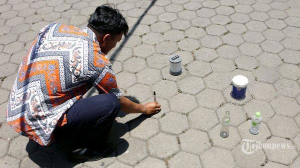 A man in Indonesia laying down objects to observe Zero Shadow Day.