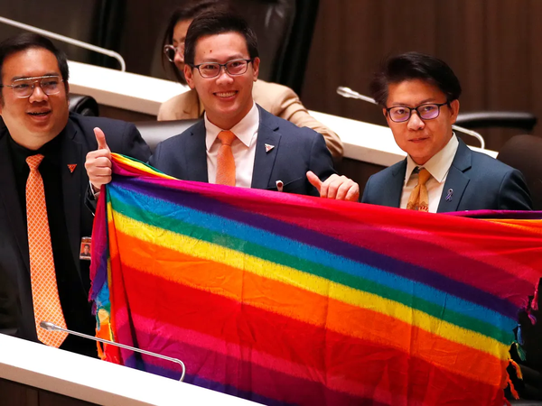 Thai lawmakers inside parliament celebrate the passing of the marriage equality bill.