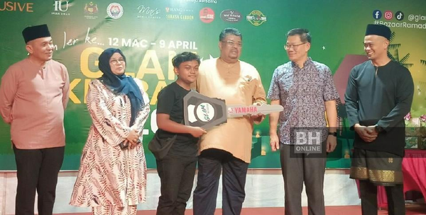 Melaka Chief Minister Datuk Seri Ab Rauf Yusoh (third from right) presenting a prize to a lucky draw winner last night, 7 April.