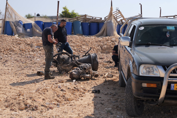 A police officer inspects the remains of a rocket booster that, according to Israeli authorities critically injured a seven-year-old girl, after Iran launched drones and missiles towards Israel, near Arad, Israel, 14 April.