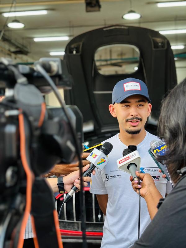 Tunku Putera Tunku Abu Bakar Sultan Ibrahim speaking with reporters at the team garage.