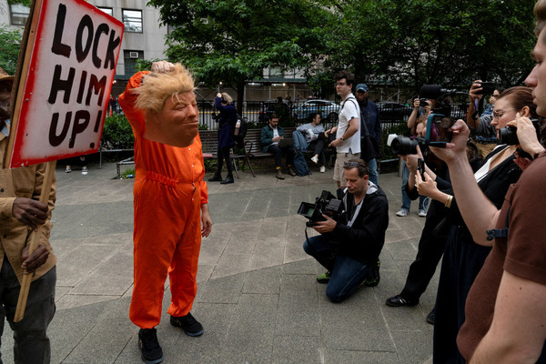 A person holds a mask while impersonating Republican presidential candidate and former US President Donald Trump outside the Manhattan criminal court following the announcement of the verdict in Trump's criminal trial over charges that he falsified business records to conceal money paid to silence porn star Stormy Daniels in 2016, in New York City, US.