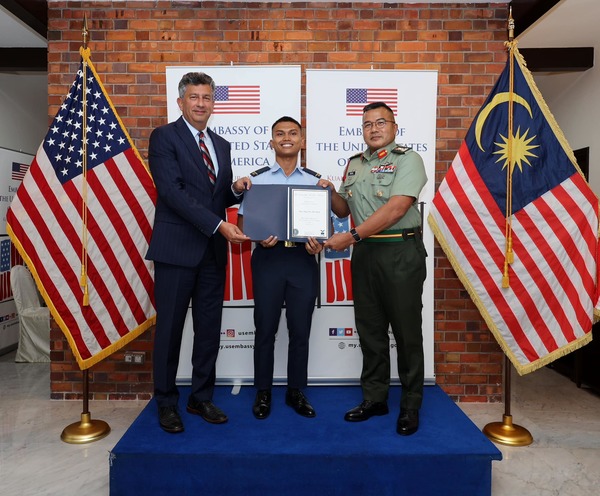 Cadet Akmal Musyrif Mohd Shariff (middle) receives his admission letter from the US Embassy Deputy Chief of Mission, Manu Bhalla (left), and Major General Datuk Reizal Arif Ismail of the 4th Malaysian Infantry Division (right).