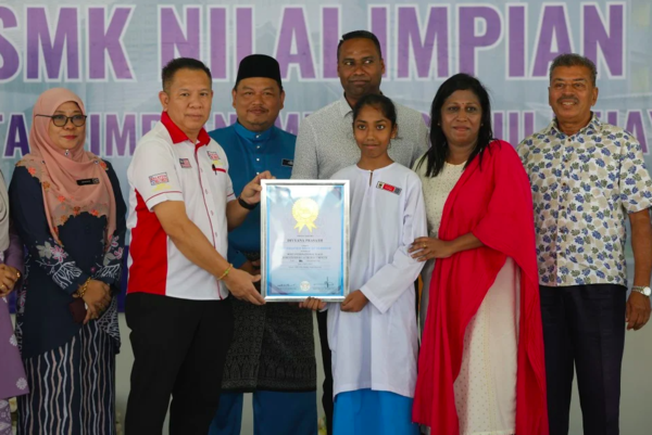 Divyana ketika menerima sijil Malaysia Book of Records (MBOR) 'Most International Flags Identified by a Child in a Minute' dari wakil MBOR, Edwin Yeoh Tiong Chin selepas berjaya memecah rekod berkenaan hari ini.