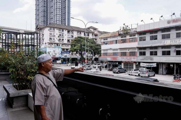 Mior Mohd Zain pointing at the sidewalk in front of the mosque, where prostitutes allegedly seek customers at night.