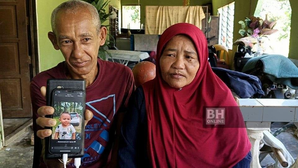 Muhammad Nazar (left) and Saadiah Yaacob showing a photo of Muhammad Luth Syauqi Nur Sufian.