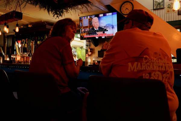 People sit at a restaurant called Somewhere where US President Joe Biden can be seen on a TV screen, on the day he announced he is stopping his bid for re-election, in Rehoboth Beach, Delaware, US, 21 July, 2024.