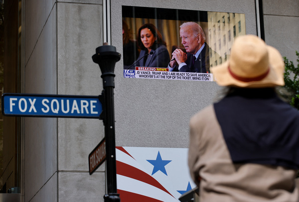 A person looks at a screen, as news on US President Joe Biden's announcement that he is dropping his re-election bid is displayed, in the Manhattan borough of New York City, US, 21 July, 2024.