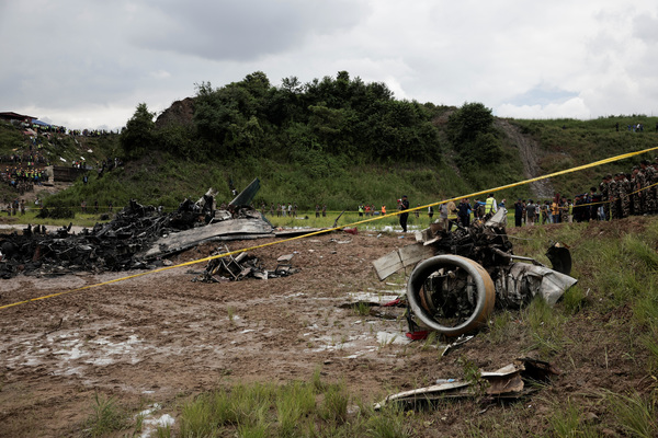 Emergency personnel work at the accident site of a Saurya Airlines plane that caught fire after skidding off the runway while taking off at Tribhuvan International Airport, in Kathmandu, Nepal 24 July, 2024.