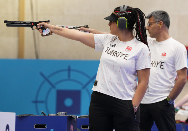 Sevval Ilayda Tarhan (left) also had her left hand in her pocket while competing at the 10m air pistol mixed team event in the Chateauroux Shooting Centre in Deols, France on Tuesday, 30 July, with her partner Yusuf Dikec.