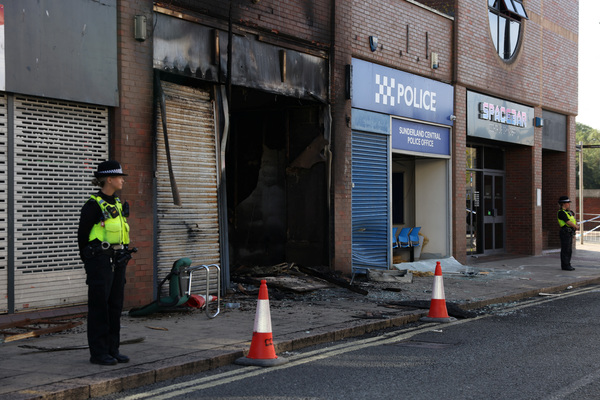 A police officer standing next to Sunderland Central Police Office after a night of violent anti-immigrant demonstrations in Sunderland, Britain on 3 August.