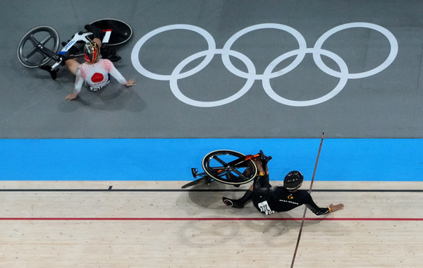 Shinji Nakano of Japan and Muhammad Shah Firdaus Sahrom of Malaysia crash during the men's keirin finals at the Paris Olympics.