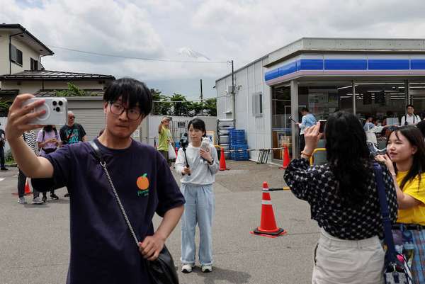 Tourists posing for photos in front of a Lawson convenience store on 21 May.