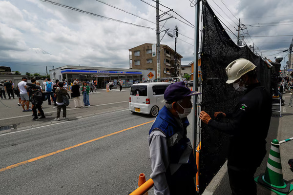 Workers are seen erecting the black mesh screen to block the popular Mount Fuji photo spot on 21 May.