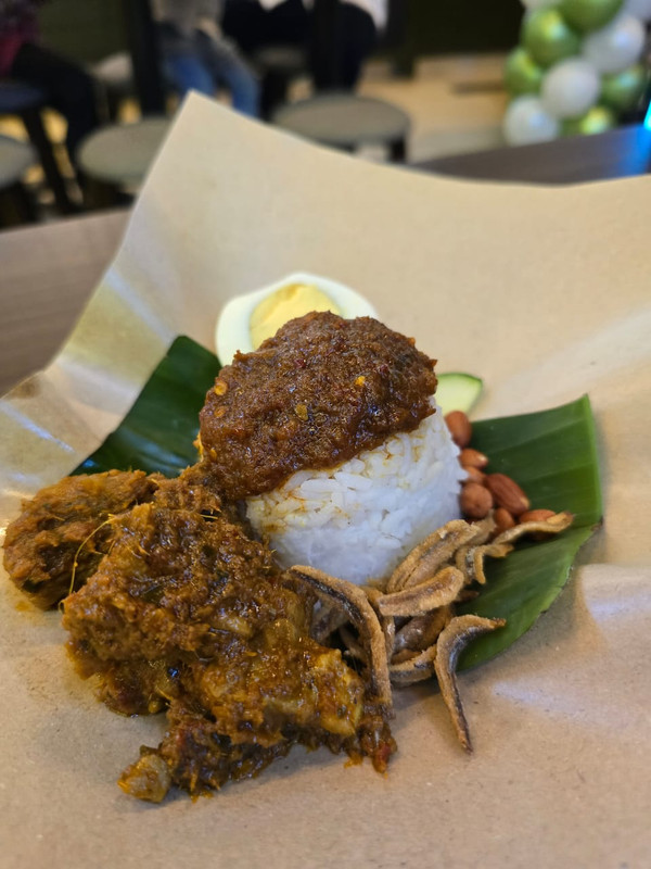 A photo provided by Bungkus Kaw Kaw showing how the chicken rendang is usually served with their nasi lemak in-store.