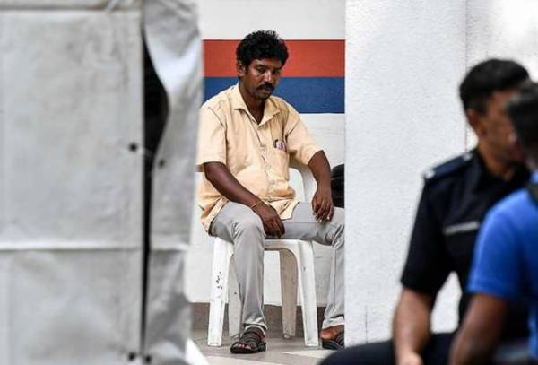 Vijaya's husband, Mathavan, looks on as the search continued on Sunday, 25 August.